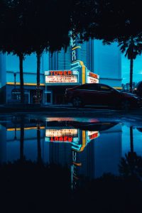 Night scene with vintage car reflections in a neon-lit urban parking lot. Captivating urban mood.